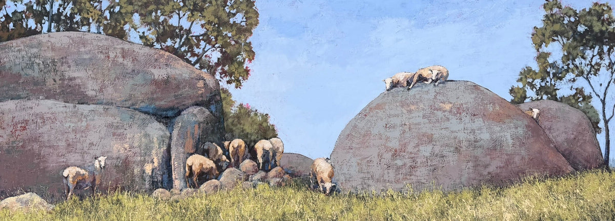 An original oil painting of pastoral landscape showing a flock of sheep grazing and resting among large rounded boulders and grass under a bright blue sky with trees.  By contemporary Australian Artist Shay Pappas